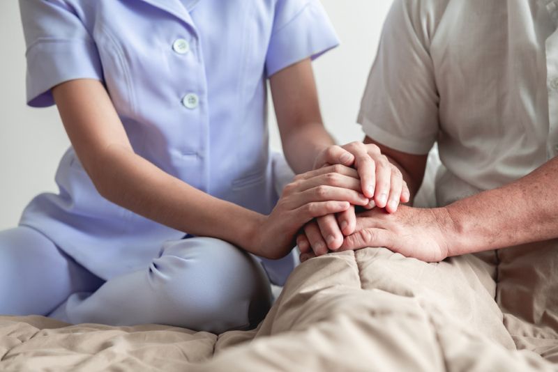 nurse consoling patient in nursing home
